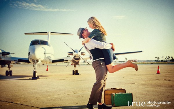 San Diego Wedding Photographer: Engaged couple seeing eachother at the San Diego airport with suitcases