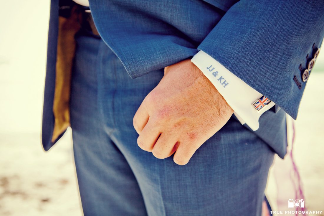 Close-up of groom wearing cuff links and and monogrammed dress shirt