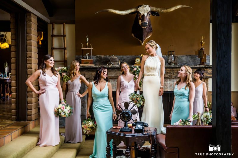 Bohemian bride standing and laughing with bridesmaids