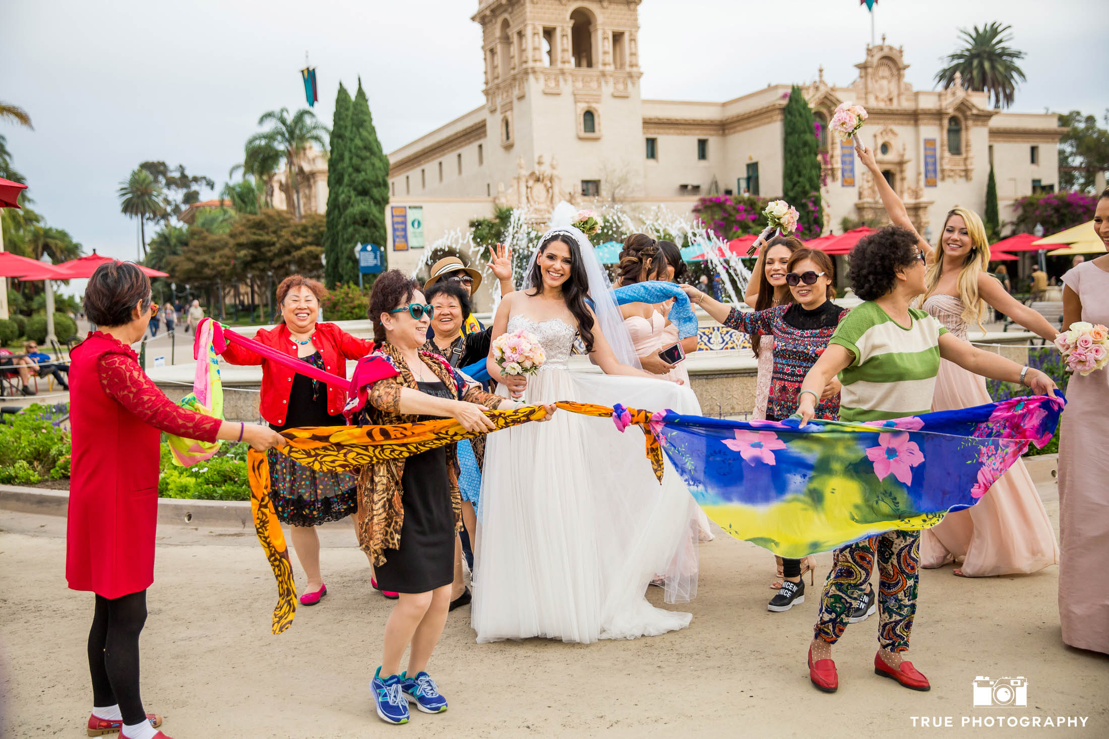 Street performers dance with scarves around Bride after wedding ceremony