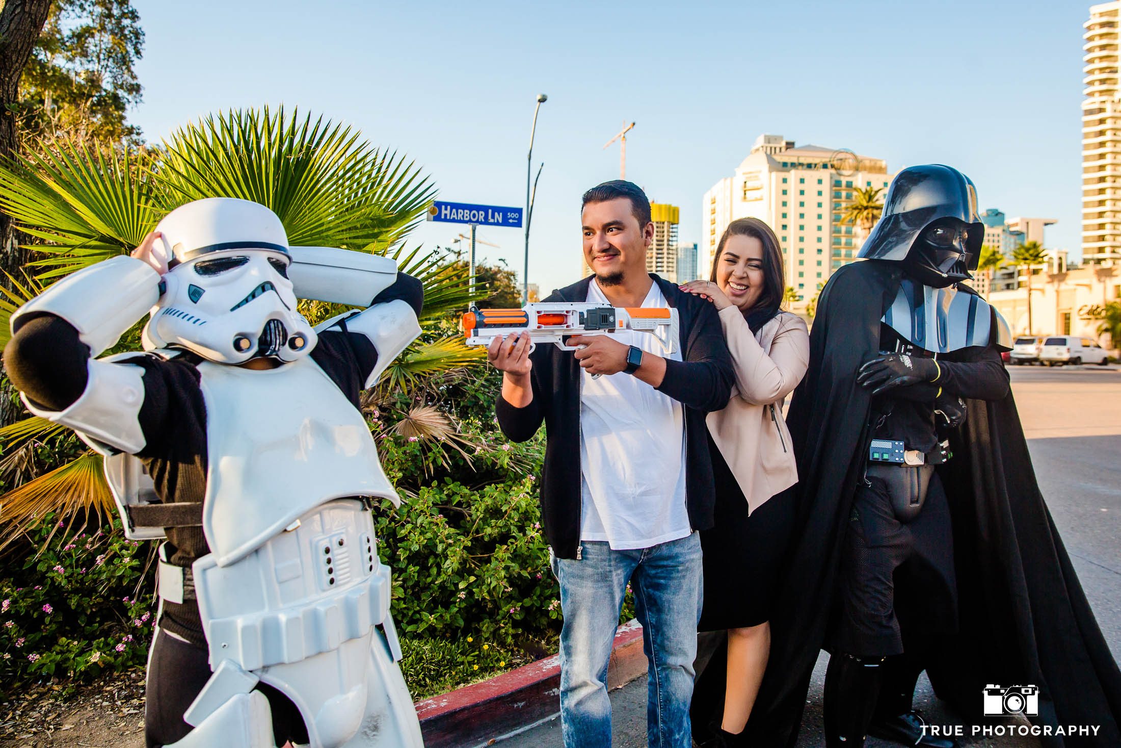 Engaged couple have fun playing with Star Wars characters in Downtown San Diego